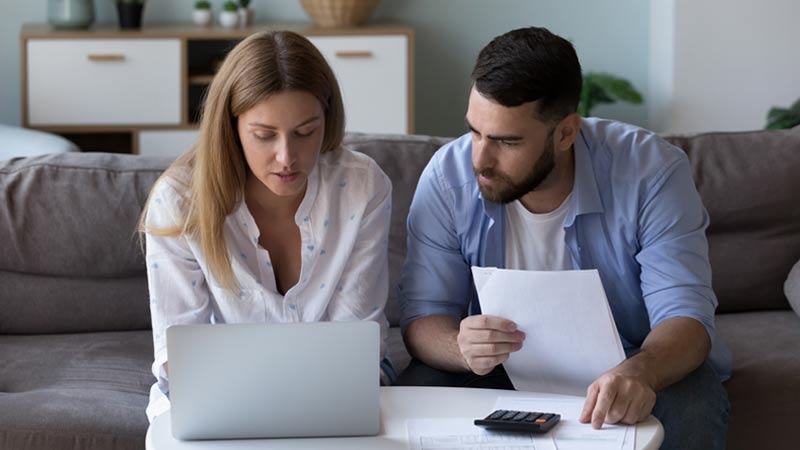 Casal português a fazer contas em frente a um computador